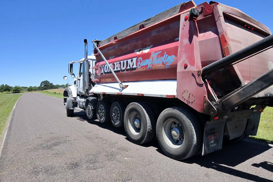 Mack asphalt dump truck with an angled tailgate designed to control hot asphalt